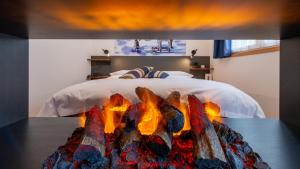 马代西莫阿尔皮娜体育酒店的一间卧室配有一张床,旁边设有壁炉