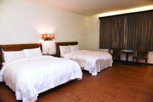 宜兰市英格兰精品汽车旅馆的酒店客房设有两张床和窗户。