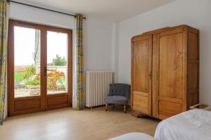 BrimontLa Ferme de Wary的一间卧室设有木制橱柜和窗户。