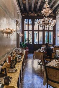 威尼斯卡马迪酒店住宿加早餐旅馆的一间设有长桌的餐厅,有坐在餐桌旁的人