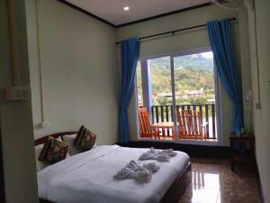NongkhiawArthith Guesthouse的一间卧室设有一张床和一个大窗户