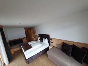 拉伊翁Hotel Andechserhof & Mountain Sky的卧室享有上方的景致,配有1张床和1张沙发