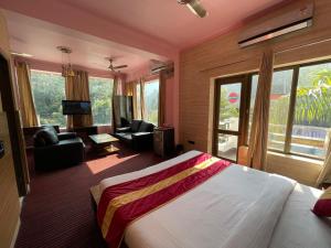 瑞诗凯诗Chanakya Resort的一间带大床的卧室和一间客厅