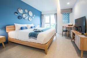 芭堤雅市中心DeeProm Pattaya Hotel的一间卧室设有一张床和蓝色的墙壁