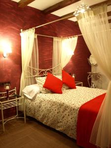 Villar del Humo卢瓦乐斯帕洛玛阿帕特门酒店的一间卧室配有一张带红色枕头的天蓬床