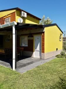 VictoricaCabañas bajos medanales的黄色的房子,设有门和庭院