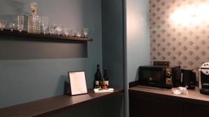 里昂MiHotel Bellecour的客房设有带微波炉和葡萄酒瓶的柜台。