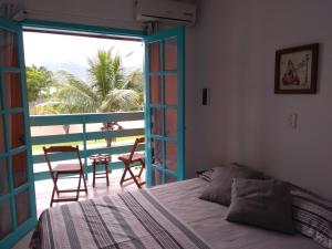 马蒂尼奥斯Pousada Gaucha Caiobá的一间卧室设有一张床,享有阳台的景色