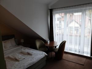 库瑞尼卡慕斯卡Apartamenty Donald的一间卧室配有一张床、一张桌子和一个窗户。