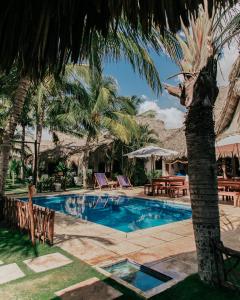 El Paredón Buena VistaParedon Surf House的一个带棕榈树和椅子的游泳池