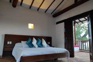巴里查拉Casa Ceiba de Mirabel-Barichara的一间卧室配有一张带蓝色和白色枕头的床