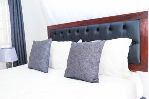 基苏木Sofitel 4 bedrooms maisonette Milimani的一间卧室配有带白色枕头的床