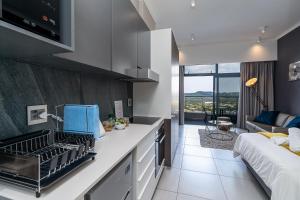 比勒陀利亚Top Floor Menlyn Maine studio apartment with Stunning Views & No Load Shedding的一个带水槽的厨房和一张沙发