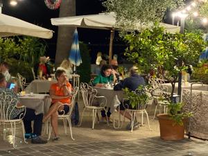 利莫内-苏尔加达Albergo Bellavista的夜间坐在户外餐厅的桌子上的人