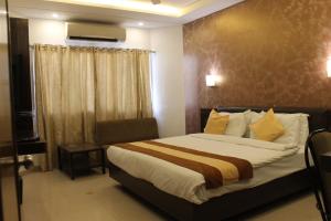 艾哈迈达巴德Hotel Kanak的酒店客房设有床和窗户。