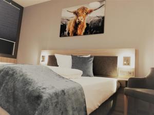 Kölleda阿尔特莫克雷克尔达餐厅酒店的卧室配有一张床,墙上挂着一头牛的照片