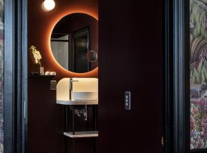惠灵顿Naumi Studio Wellington的一间带水槽和镜子的浴室