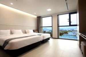 大田Hotel Skypark DaejeonⅠ的配有大窗户的酒店客房内的两张床