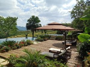 Pu LuongPuluong Home的一个带遮阳伞和椅子的庭院和一个游泳池