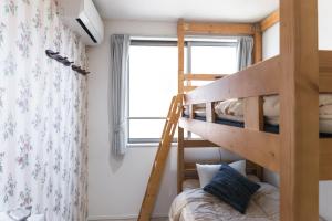 东京nestay inn tokyo senju的配有梯子的小客房内的双层床