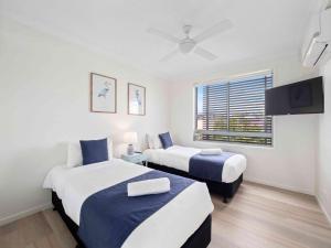 科夫斯港太平洋滨海公寓式酒店的一间卧室配有两张床和一台平面电视