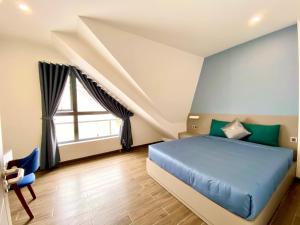 大叻Kim Oanh Apartment的一间卧室设有蓝色的床和窗户。