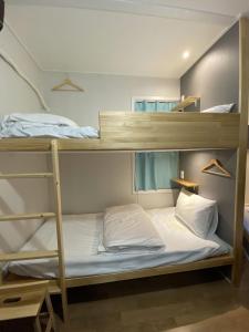 釜山但丁之家旅馆的一间卧室配有两张双层床。