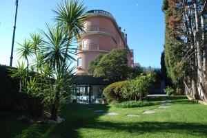 基亚瓦里圣塔玛丽亚酒店的前面有棕榈树的粉红色建筑