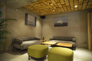 恒春古城三富大酒店FFF Hotel 的客房设有两张沙发和一张桌子及椅子。