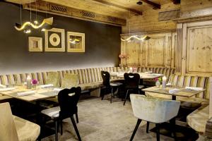 萨菲登安斯泰内嫩米尔Brandlhof lodge的餐厅拥有木墙和桌椅