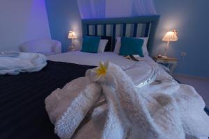 阿林达Saraya Resort的一间卧室配有一张带白色毛巾和鲜花的床