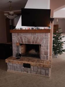 伯伊莱图什纳德Villa Atriolum的砖砌壁炉顶部的电视,壁炉上拥有圣诞树