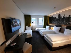韦特海姆Euro Hotel Wertheim的酒店客房设有两张床和一台平面电视。