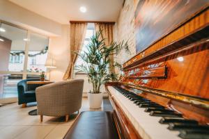 布拉格COLORFACTORY SPA Hotel - Czech Leading Hotels的客厅配有钢琴和椅子