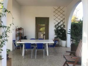 马鲁焦Villa Lucia的客房内的白色桌子和蓝色椅子