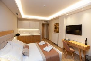 塞萨洛尼基No21 Luxury Suites的一间卧室配有一张床、一张书桌和一台电视