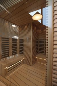 阿斯塔纳The Veil Hotel的配有木制百叶窗和灯的桑拿浴室