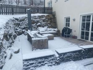 卡普伦AlpinResort Kaprun 1的一个带沙发和石墙的雪覆盖的院子