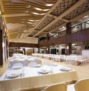 伊万诺-弗兰科夫斯克NeboS Hotel & Restaurant的一个带白色桌椅的大型宴会厅
