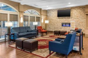 布卢明顿Comfort Inn MSP Airport - Mall of America的客厅配有蓝色椅子和电视