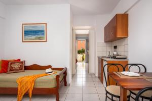赫索尼索斯美丽酒店公寓的配有床和桌子的房间以及厨房