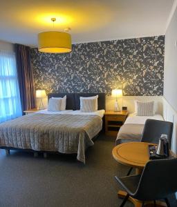 's-GravenmoerHotel Hof van 's Gravenmoer的酒店客房带两张床和一张桌子以及椅子。