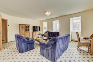 阿尔肯齐梦曼公寓式酒店的客厅配有2把蓝色椅子和桌子