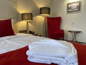 托木斯克Кухтерин Отель的一间卧室配有一张床和一张红色椅子