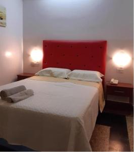 布宜诺斯艾利斯León Imperial的一间卧室配有一张大床和红色床头板