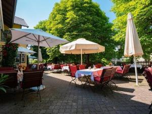 费尔达芬格格斯豪斯波特酒店的一个带桌椅和遮阳伞的庭院。