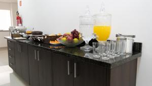 圣若泽杜斯皮尼艾斯Hotel Carmelo的厨房柜台,配有一碗水果和玻璃杯