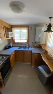 圣马丁德洛斯Samay Huasi - 3 dorm en suite - inmejorable ubicación - cochera cub的厨房配有木制橱柜、水槽和窗户。