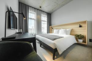帕维洛斯塔OTTO Hotel & Sun的配有一张床和一张书桌的酒店客房