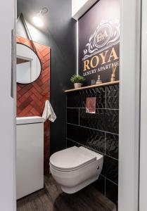 比得哥什E&A Royal Luxury Apartments, Bydgoszcz - SKYLINE的浴室设有白色卫生间和黑色墙壁。